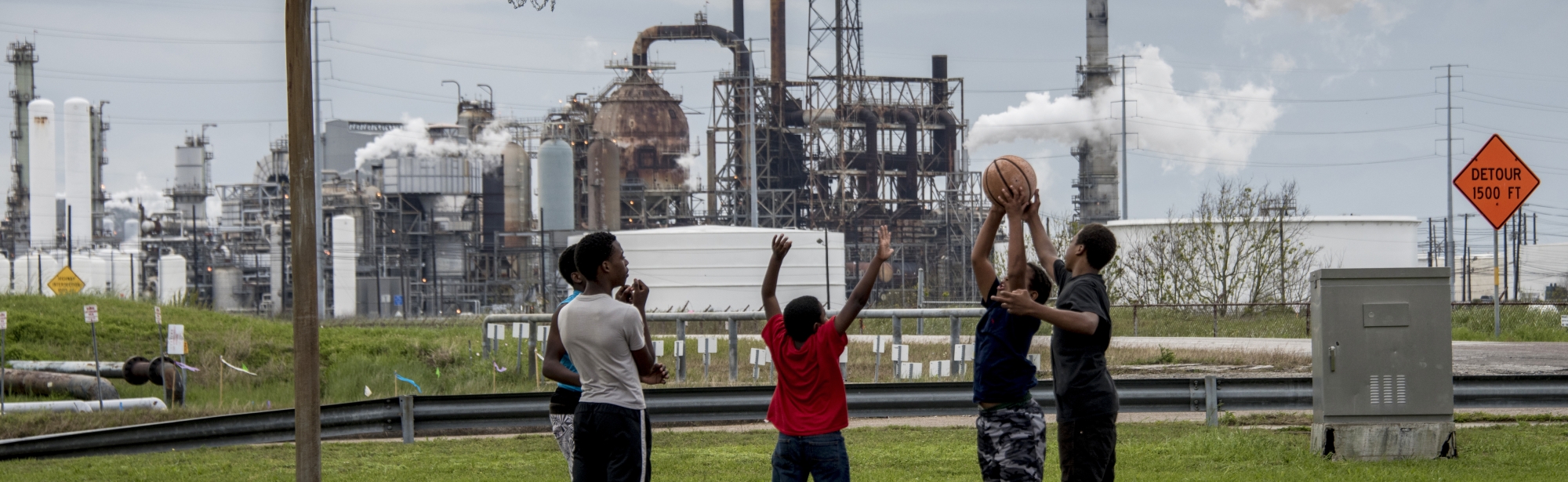 Boys playing basketball near a refinery in Port Arthur, Texas. Photo via KAREN KASMAUSKI/SCIENCE PHOTO LIBRARY