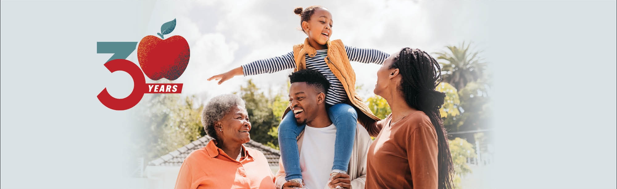 30 Years logo and photo of a senior woman with adult offspring and granddaughter standing under sun and smiling cheerfully on terrace at home, little girl sitting on father's shoulders