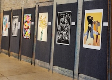 Row of posters on display at the 2022 I Heart Justice exhibition in downtown Austin 